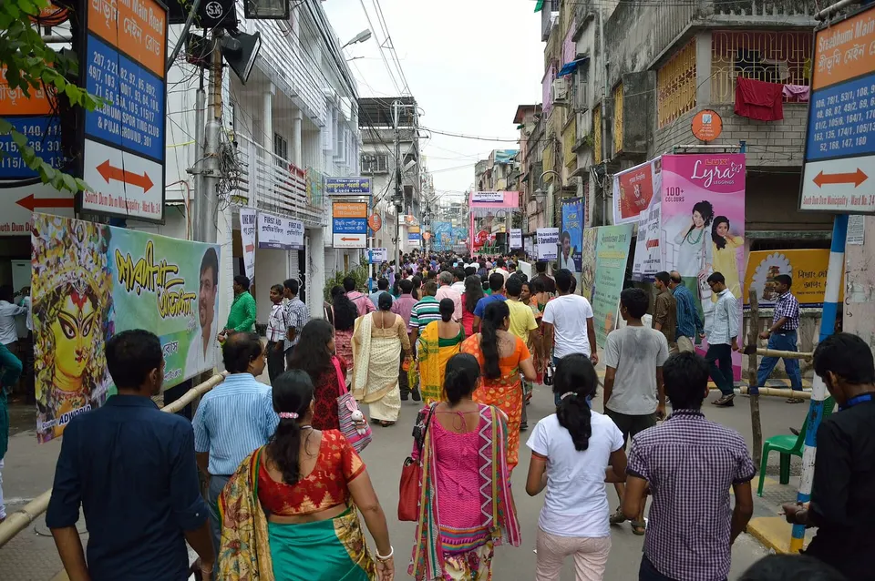 Crowds walking along Sreebhumi Main Road during Durga Puja