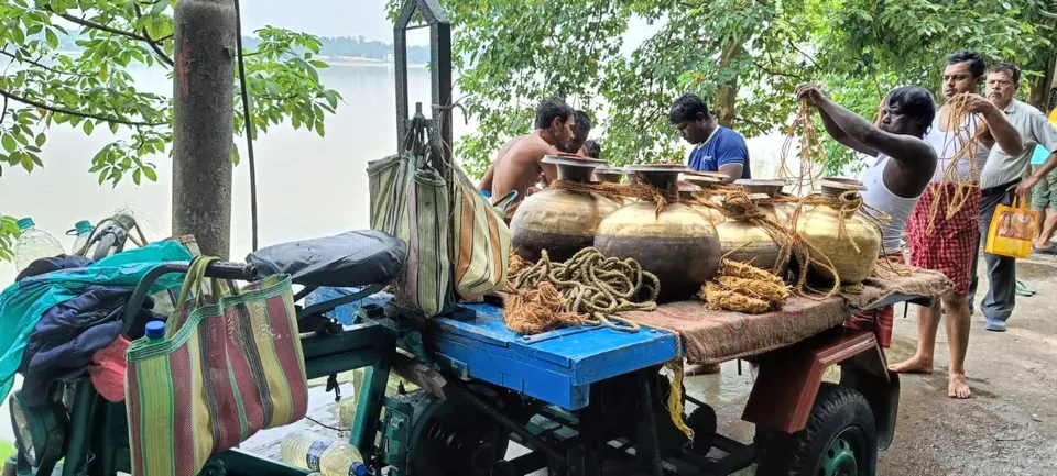 Family members tying the pots of Ganga water onto the cart